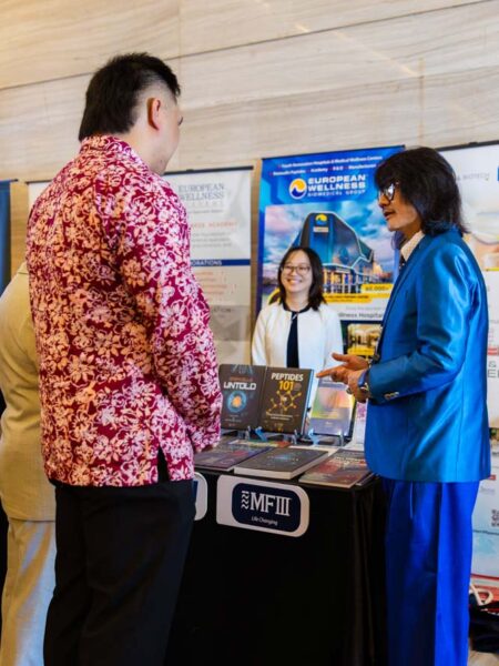 Prof. Dato’ Sri Dr. Mike Chan introduces his scientific and medical publications to Sabah Education, Science, Technology, and Innovation Assistant Minister YB Tuan Jordan Jude Datuk Ellron and other visitors at the European Wellness Biomedical Group exhibition during the symposium.